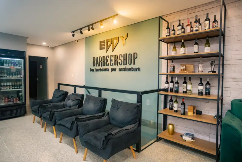 Recepção com o letreiro Eddy Barbeershop e poltronas de espera