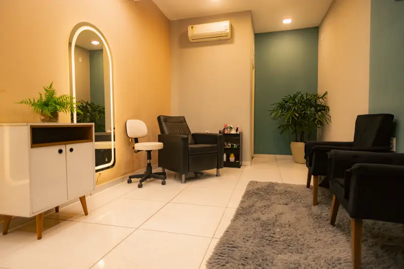 Sala de espera com poltronas e espelho em arco