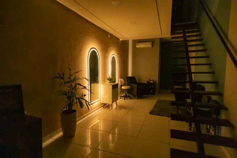 Corredor iluminado com espelhos em arco e escada
